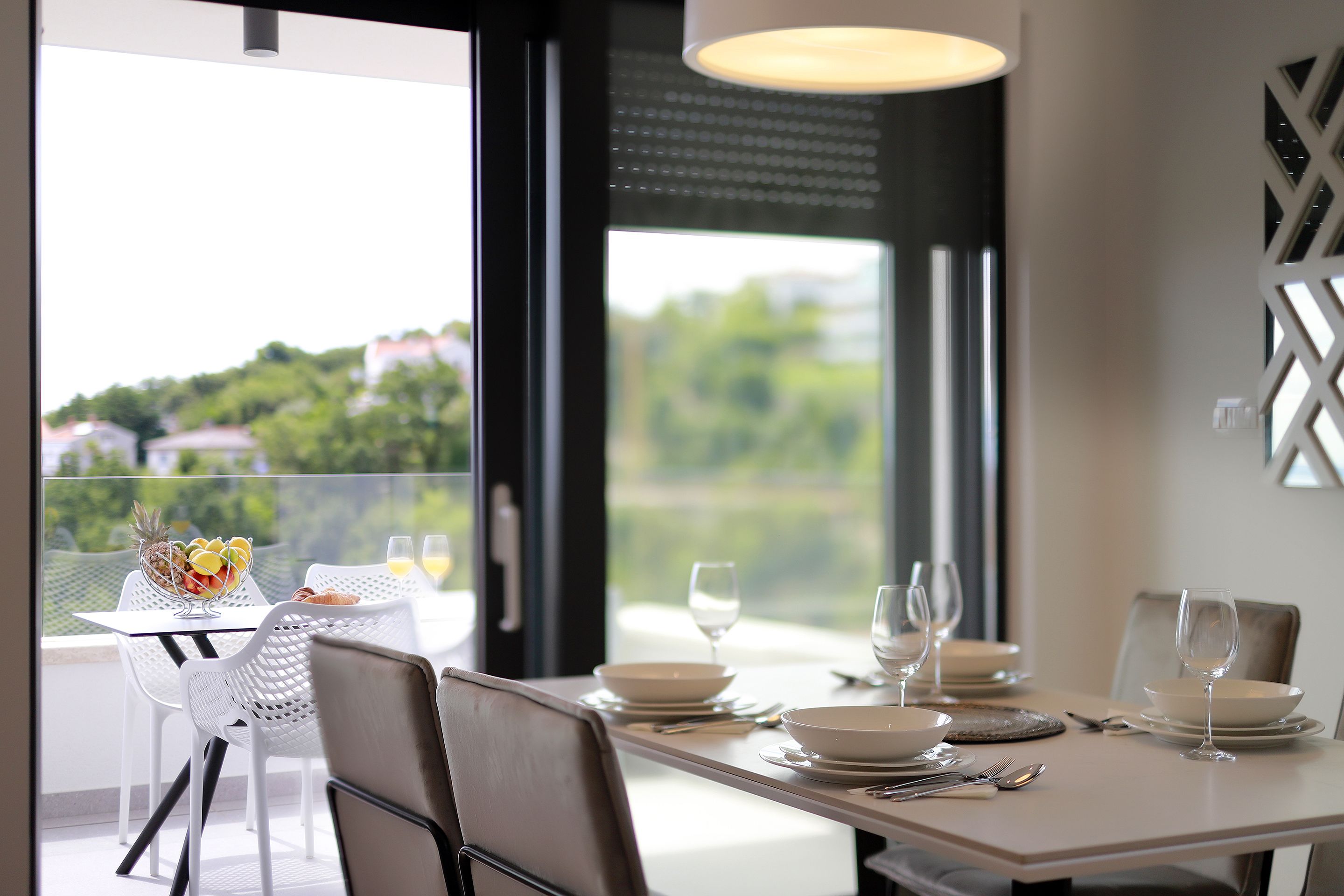 Comedor con una mesa preparada para cuatro personas, con vistas panorámicas.