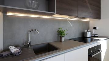 Een moderne keuken met een ingebouwd spoelreservoir, een roestvrijstalen kraan en een strak aanrecht.