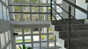 Ein modernes Interieur mit Treppe, weißen Wänden und einem Blumentopf.