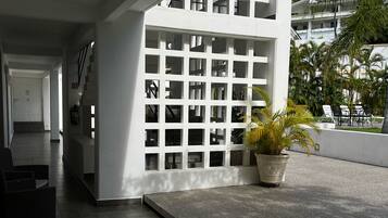 A modern interior with a staircase, a seating area, and a view of a lush garden.