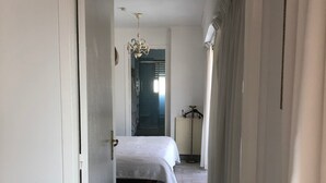 A hallway leading to a bedroom with a bed, a radiator, and a hanging light fixture. - Cannes, Palm Beach, Penthouse 50 meters from the Beach (Cannes)