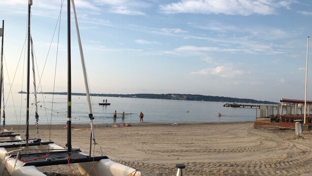 A beach with boats, a pier, and a distant shoreline. - Cannes, Palm Beach, Penthouse 50 meters from the Beach (Cannes)