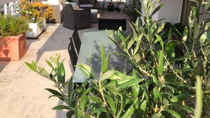 An outdoor patio area with a red awning, outdoor furniture, and potted plants. - Cannes, Palm Beach, Penthouse 50 meters from the Beach (Cannes)