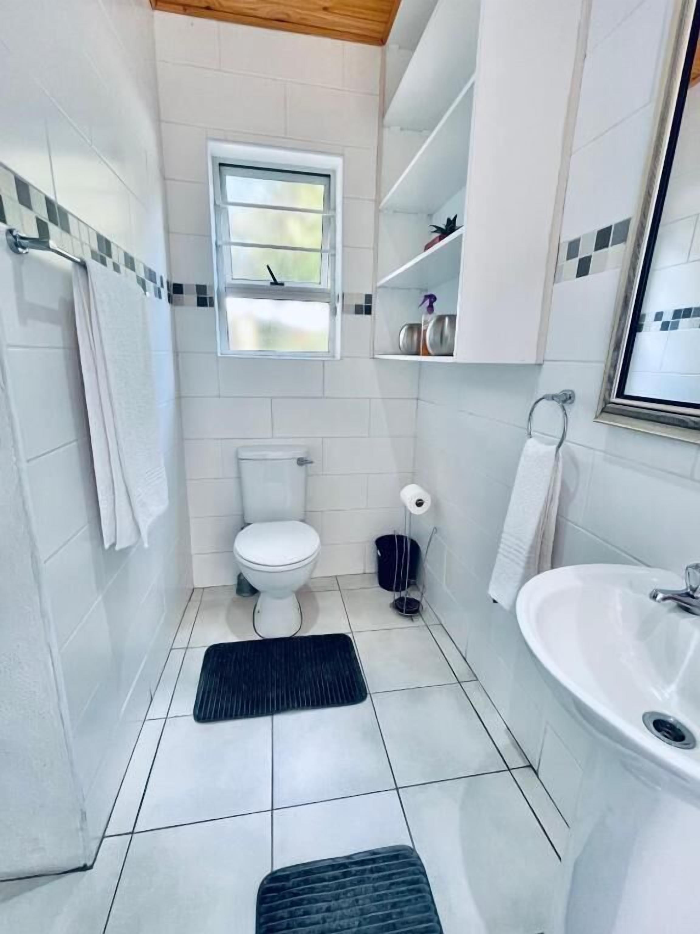 Un baño con inodoro, lavamanos y ventana.