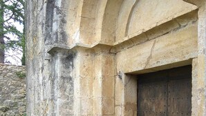 Un edificio de piedra con una puerta de madera grande y una entrada abovedada.