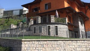 Une maison à deux étages avec une façade en pierre et un balcon.