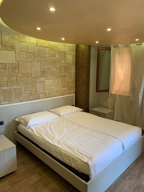 Habitación cuádruple | Ropa de cama de alta calidad, minibar, escritorio y cortinas blackout 