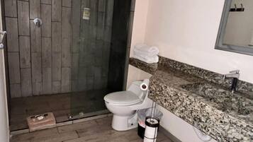A bathroom with a shower, toilet, and sink.