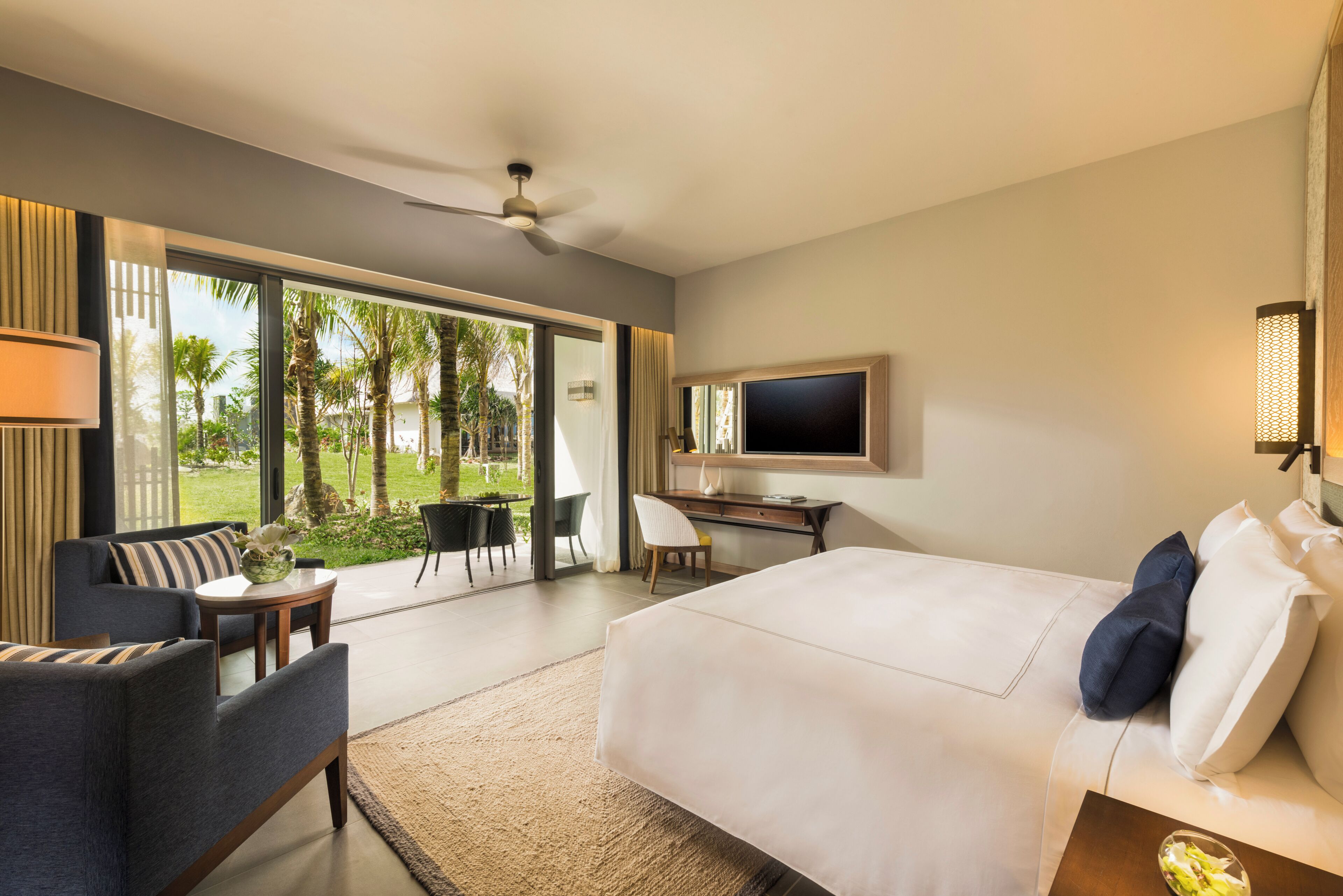Een moderne hotelkamer met een groot bed, een bureau, een stoel en een televisie.