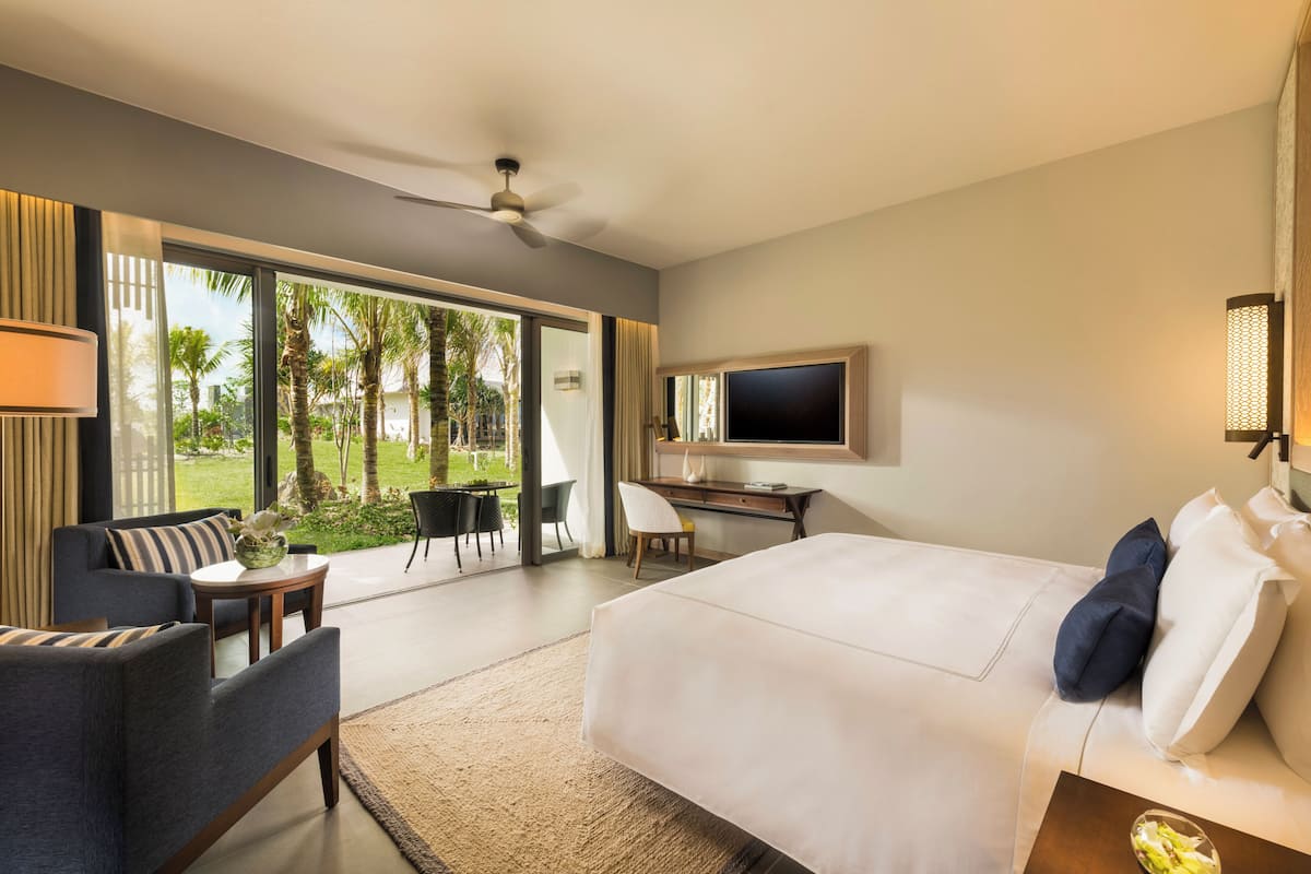 Een moderne hotelkamer met een groot bed, een bureau, een stoel en een televisie.