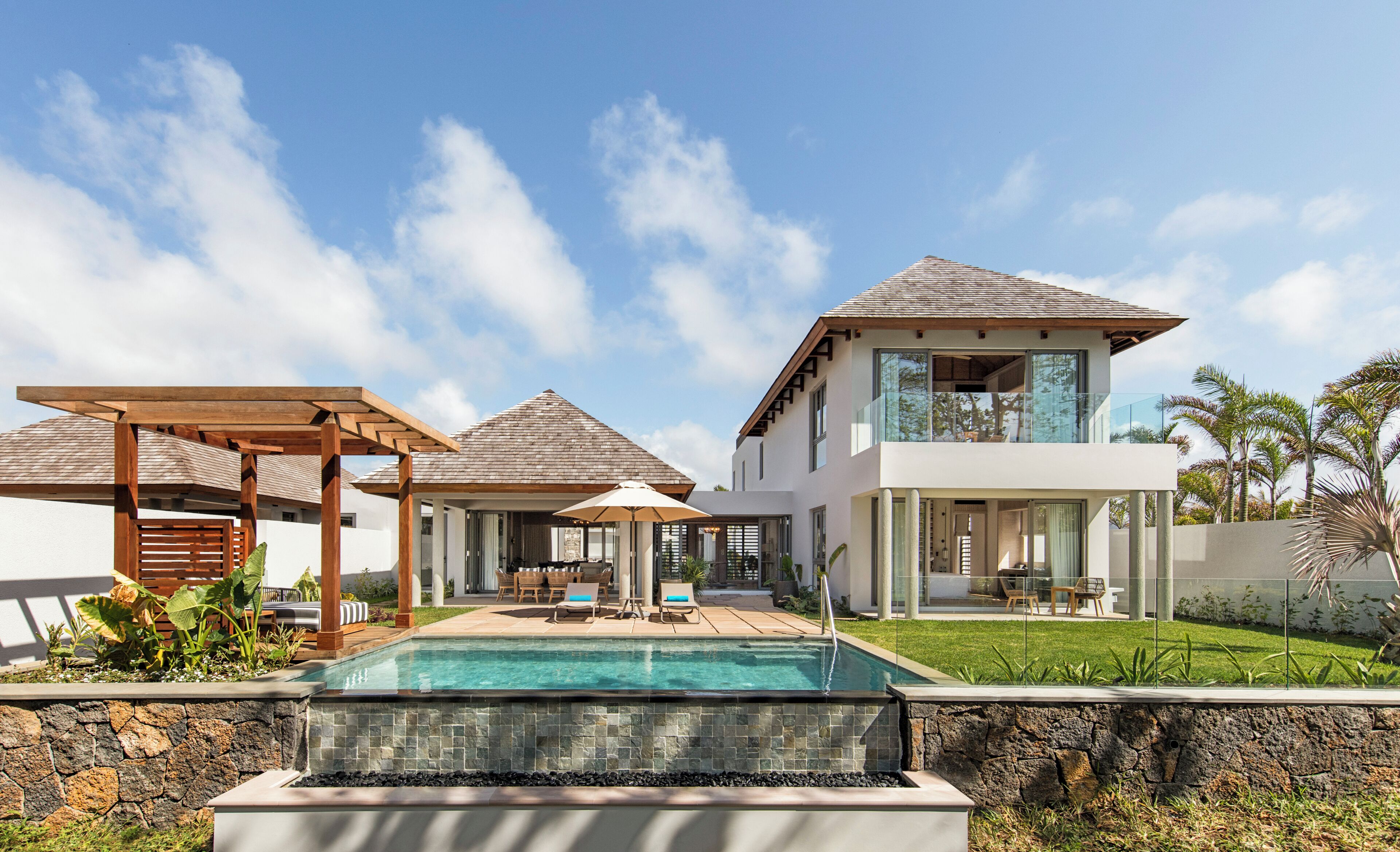 Une maison moderne dotée d’une piscine, d’un patio couvert et d’une maison d’hôtes séparée.