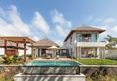 A modern house with a swimming pool, a covered patio, and a separate guest house.