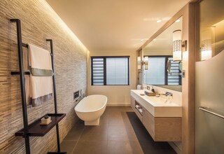 A modern bathroom with a freestanding bathtub, a large mirror, and a towel rack.