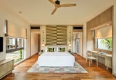 A modern hotel room with a large bed, a desk, and a view of the outdoors.