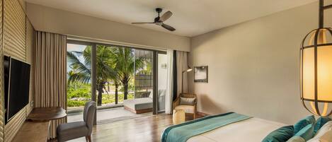 A hotel room with a bed, a desk, a chair, a TV, and a view of the outdoors.