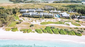 An aerial view of a resort with multiple buildings, a beach, and clear turquoise waters. - Constance Le Chaland Iko Mauritius (Blue Bay)