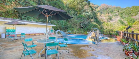 Una piscina al aire libre, sombrillas
