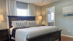 Ein Schlafzimmer mit einem dunklen Holzbett, weißer Bettwäsche und zwei Nachttischlampen.