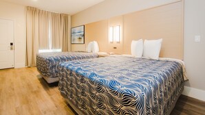 A hotel room with two beds, a large window with curtains, a painting on the wall, and a wooden headboard. - Palace Inn Blue Federal Road (Houston)