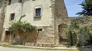 Um edifício de pedra com design tradicional, com uma janela pequena e uma porta.