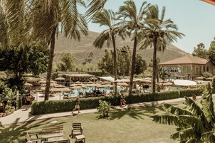 Un resort con piscina, palmeras y un edificio de techo rojo.