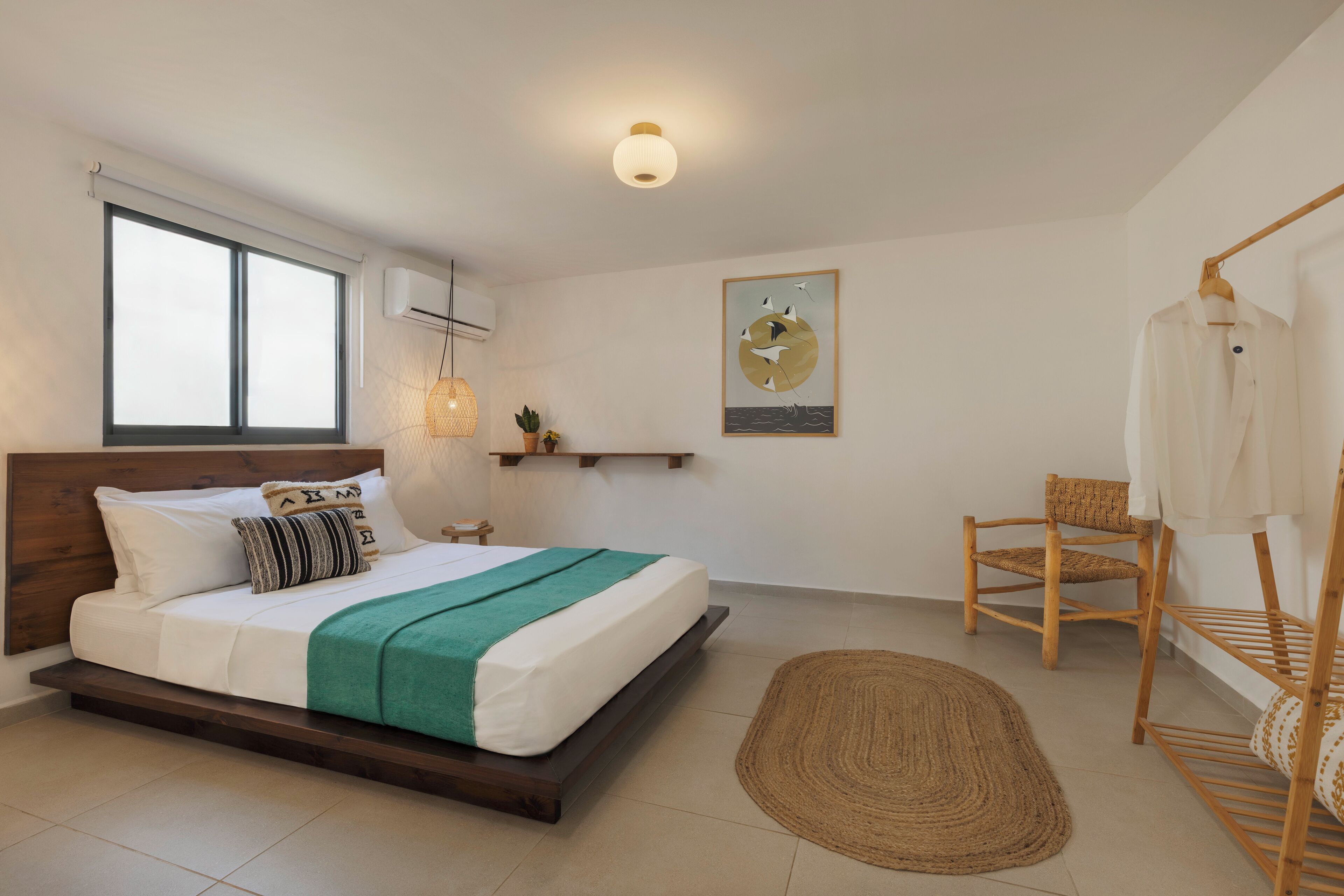 A bedroom with a bed, a hanging chair, a wall-mounted shelf, and a painting.