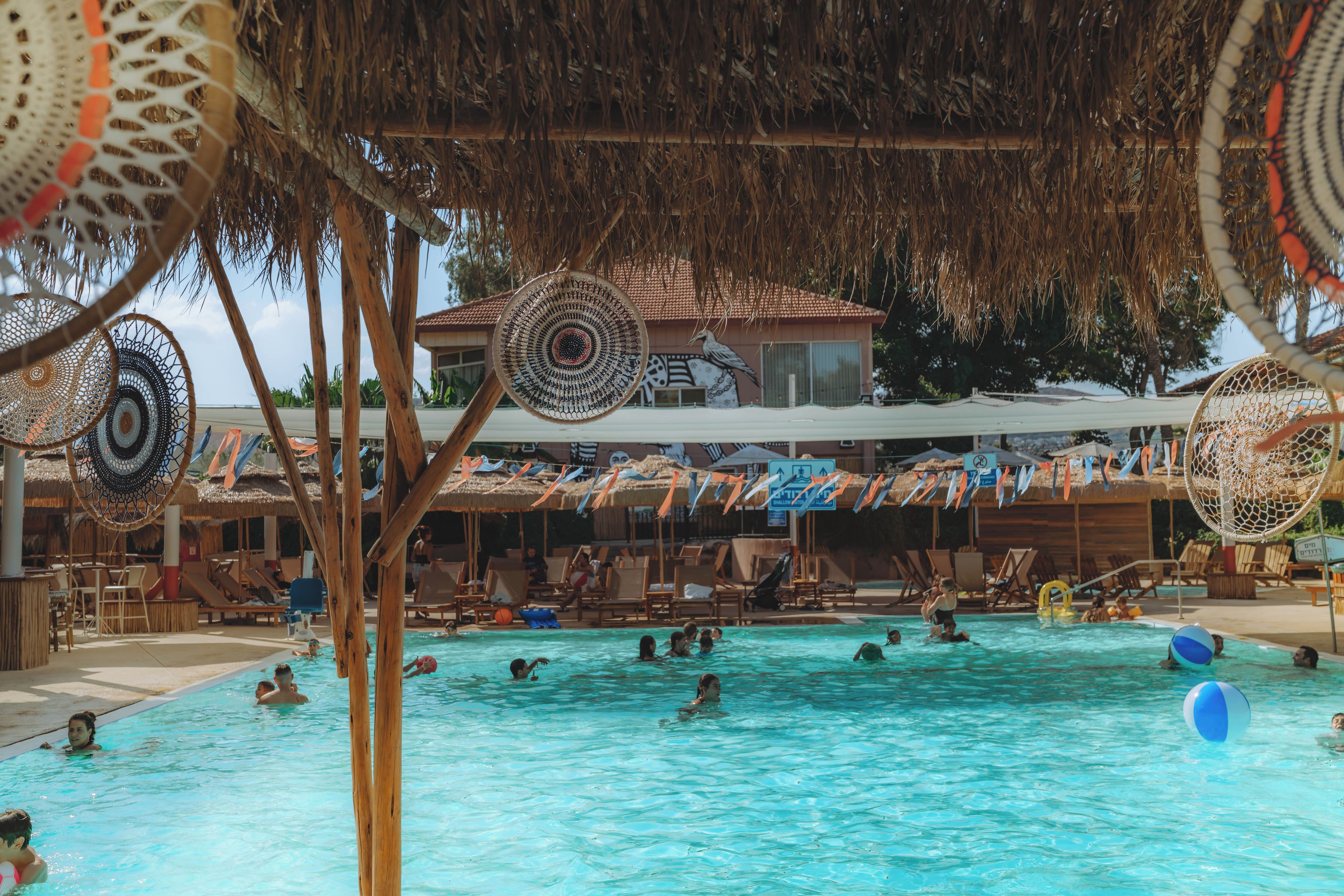 A swimming pool area with lounge chairs and umbrellas.