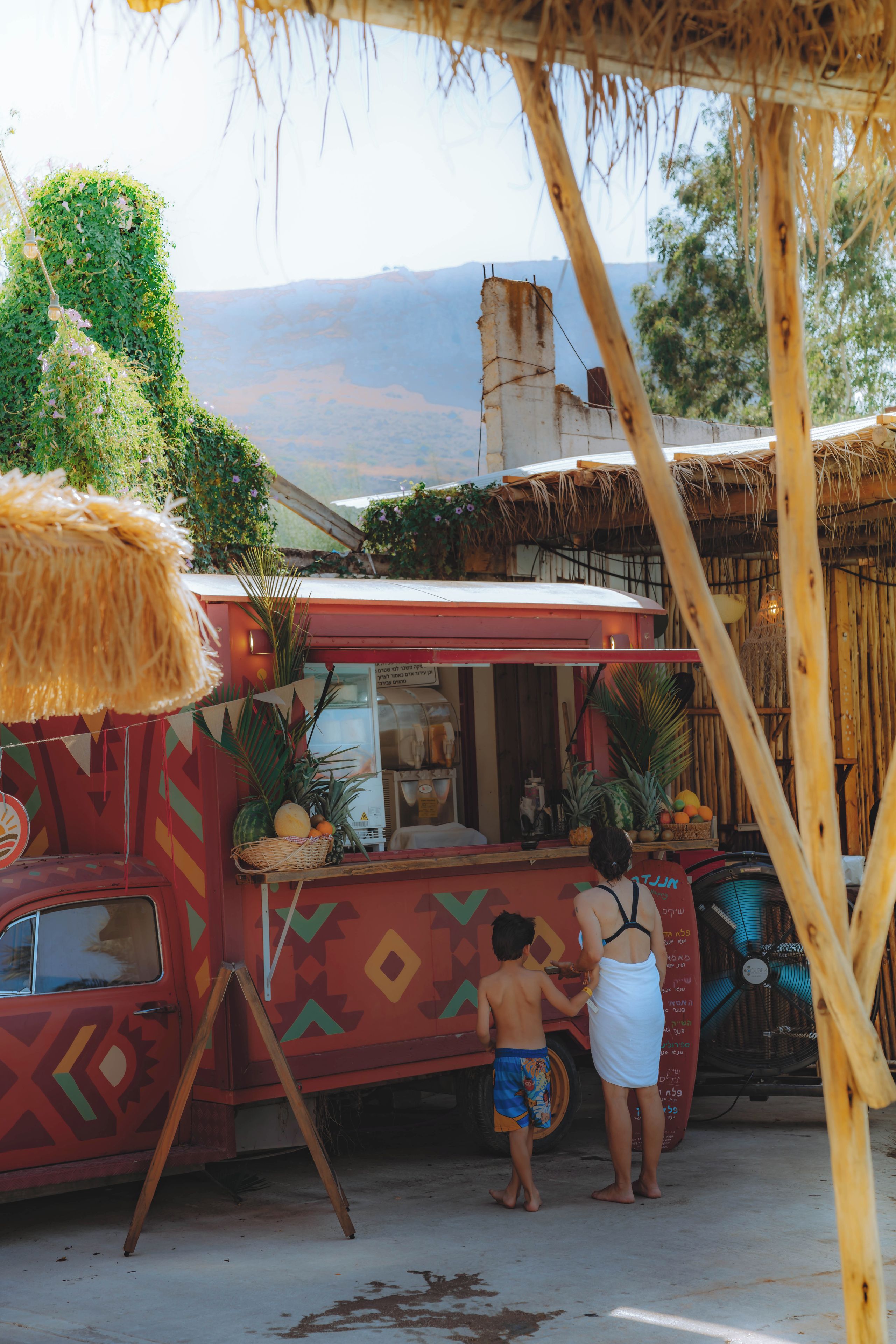 A food truck with a colorful exterior and a tropical setting.