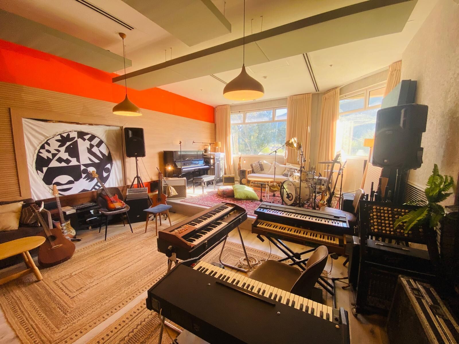 Una habitación con un piano, teclado y diversos instrumentos musicales.