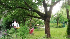 A garden with a swing, a hammock, and a small sailboat decoration. - Vacation cottage near the harbor (Lauterbach)