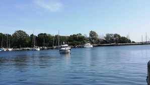 A marina with several boats docked along the waterfront, surrounded by trees and a clear sky. - Vacation cottage near the harbor (Lauterbach)