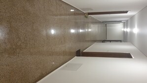 A modern, well-lit hallway with polished stone walls and a clean, white floor. - A perfect studio to stay - Studio Tony (Varna)
