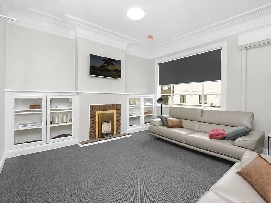 A modern living room with a fireplace, a sofa, and built-in shelving.