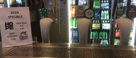 A bar area with beer specials sign, including Hope Pale Ale and Great Northern beer.