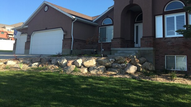 A two-story house with a brick facade, a white garage door, and a stone retaining wall. - 2000 sq foot exec apt./private vacation/quiet neighborhood close to ski resorts (Draper)