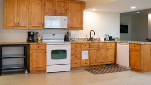 A kitchen with wooden cabinets, a microwave, stove, and dishwasher. - 2000 sq foot exec apt./private vacation/quiet neighborhood close to ski resorts (Draper)