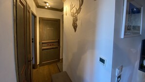 A hallway with a wooden door labeled "Salle de Bain" and a mounted deer head on the wall. - F003 - 40 m2 - 2P - 2/4 pers (Prapoutel)