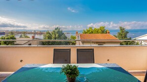 Una piscina sul tetto con vista su una città costiera, tra edifici e una distesa d'acqua.