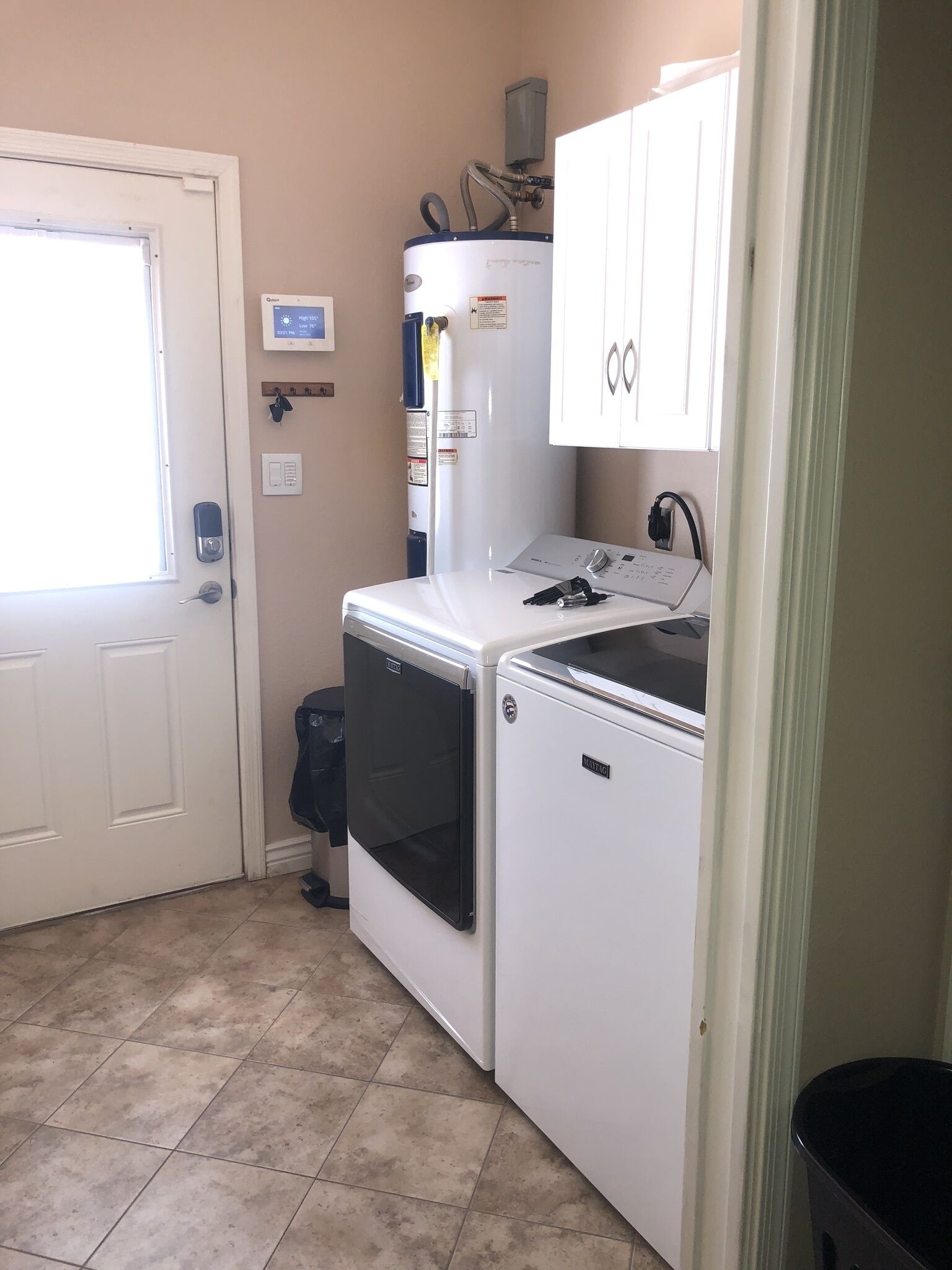 A laundry room with a washer, dryer, and a water heater.