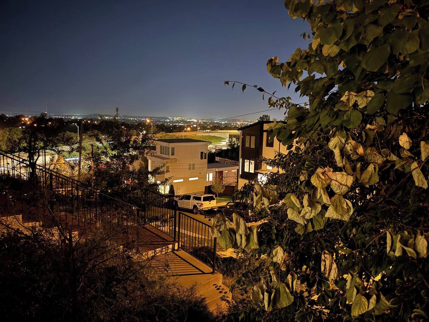 Una casa moderna con un garaje visible y una escalera que conduce a una terraza.