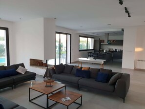 Villa – superior | Oppholdsområde | En 52-tommers Flatskjerm-TV med Parabol-TV samt TV og peis