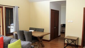 A living room with a sofa, a dining table, and a small side table.