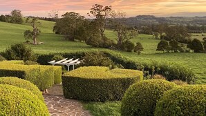 A landscaped garden with neatly trimmed hedges, a stone pathway, and a pergola structure. - Expansive Hamptons home on acreage, with pool, spa, gym, tennis court & views. (Kangaloon)