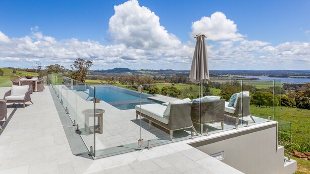 A rooftop pool area with glass railings, lounge chairs, and a view of the landscape. - Expansive Hamptons home on acreage, with pool, spa, gym, tennis court & views. (Kangaloon)