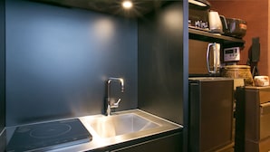 A compact kitchen with a built-in stovetop, a sink, and a microwave. - Hosta Toji Sakura (Kyoto)