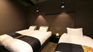 A hotel room with two beds, a nightstand with a lamp, and a window with blinds. - Hosta Toji Sakura (Kyoto)