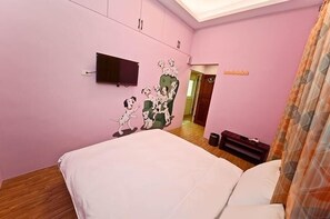 A pink-themed bedroom with a bed, a mounted TV, and a wall mural of cartoon dogs. - Painted Holiday (Liuqiu)