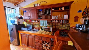 A kitchen with wooden cabinets, a tiled backsplash, and various kitchen appliances.