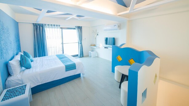 Una habitación de hotel moderna con cama, escritorio y zona de estar.