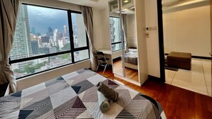 Une chambre d’hôtel moderne dotée d’un grand lit, offrant une vue sur le paysage urbain, un balcon et un coin salon séparé.